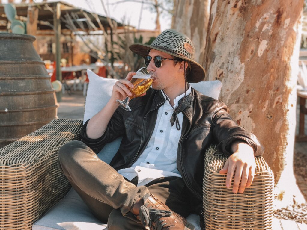 A man sitting in a chair drinking from a glass